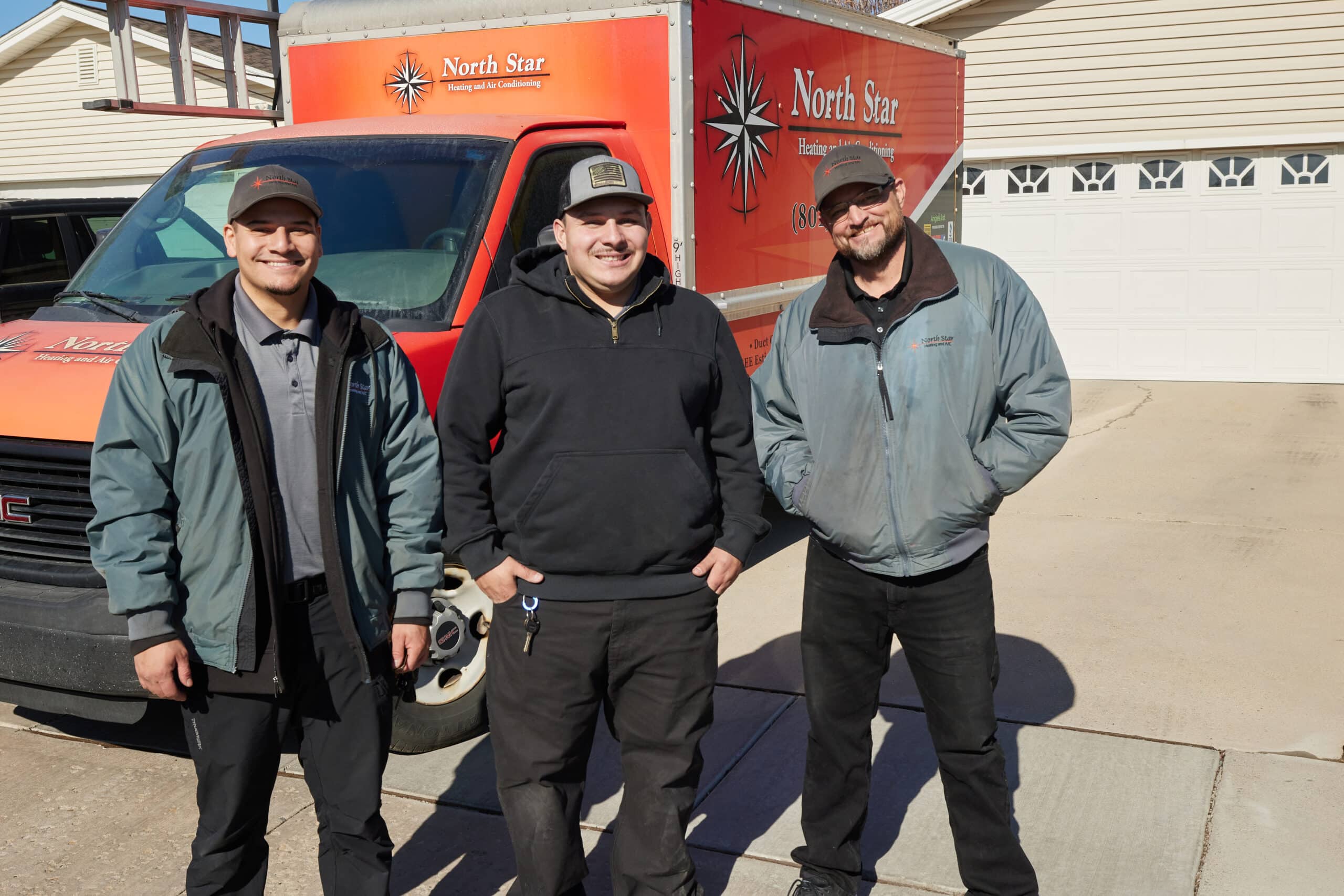 North Star Heating & Air Conditioning's team standing in front of one of their work vehicles.